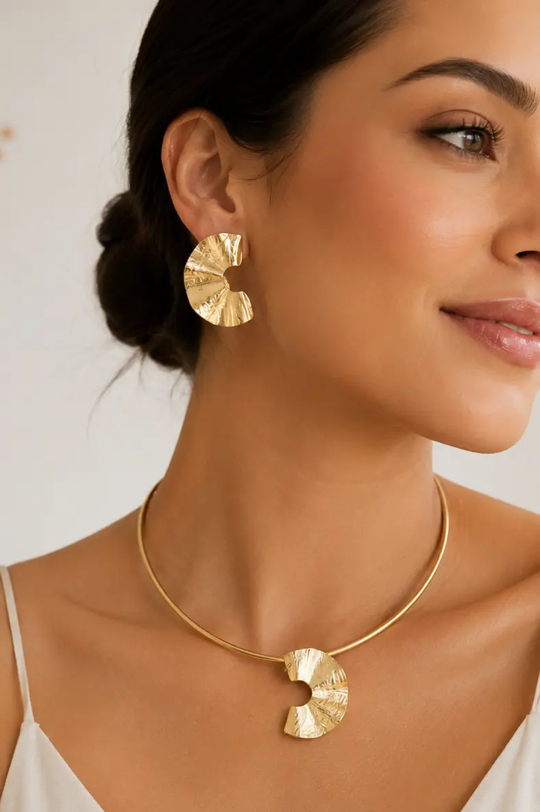 Modelo usando brincos e colar dourados em formato de leque JMA Bijoux